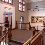 Across the landing with title wall/ Vesuivia and triptych: Once We Were Whole in the stairwell.